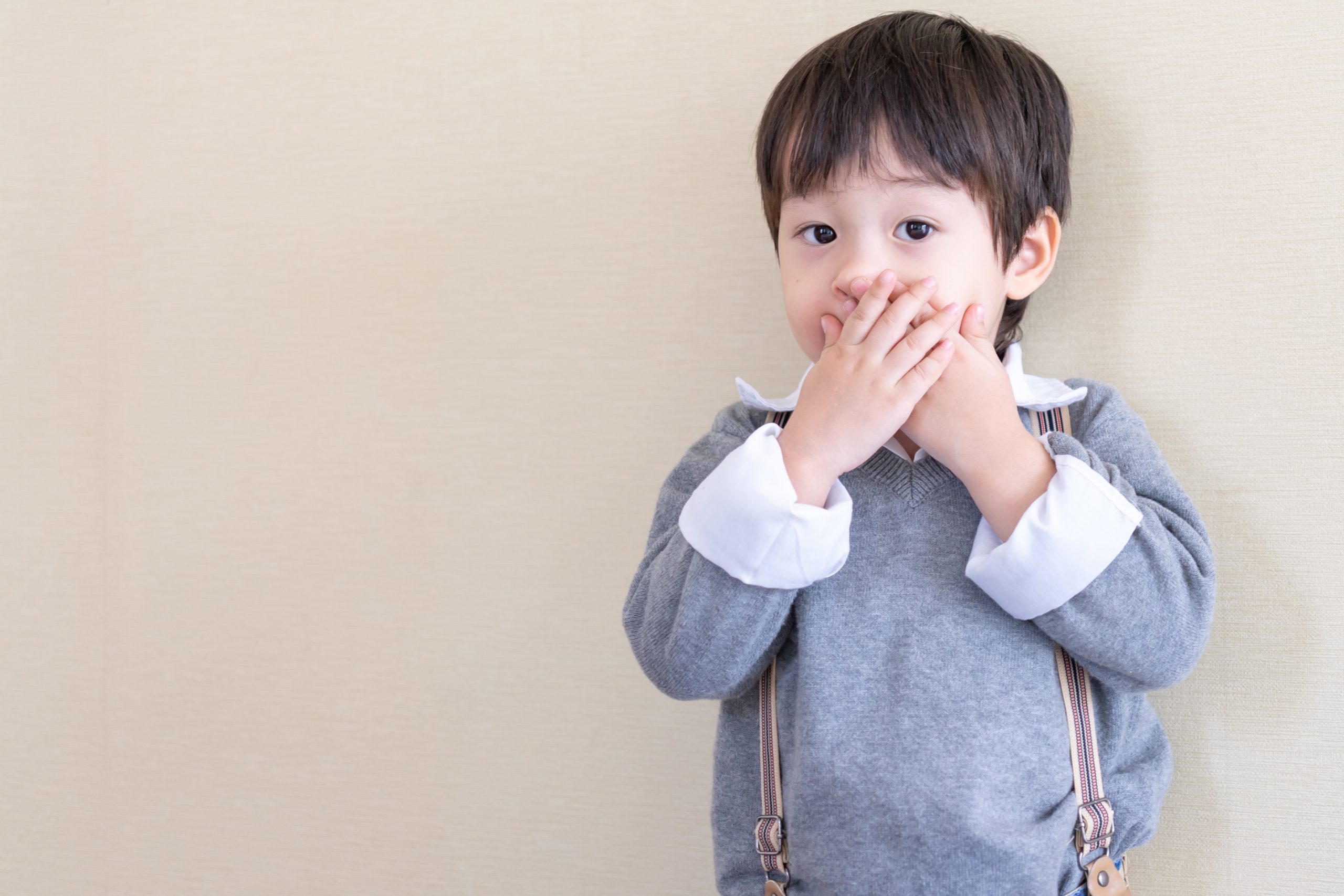 portrait asian boy standing and closed his mouth